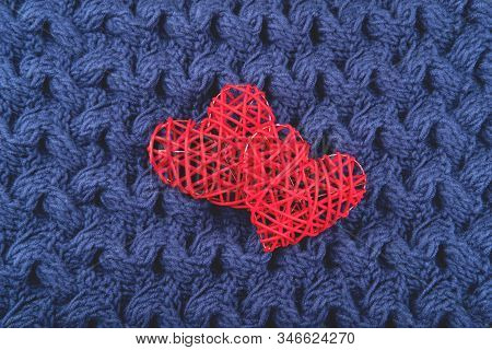 Two Beautiful Red Hearts On The Blue Knit Background. St Valentines Concept With Copy Space.