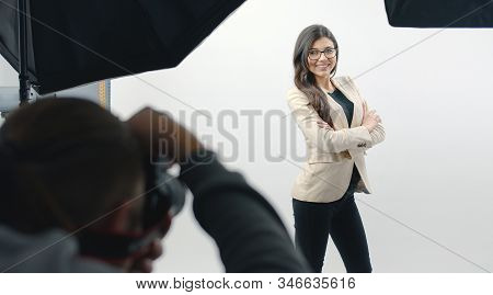 Cropped Shot Of Photographer With Camera Shooting Beautiful Young Woman In Modern Studio