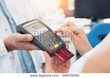 Payment By Credit Card With Terminal. Woman Enters The Pin Code