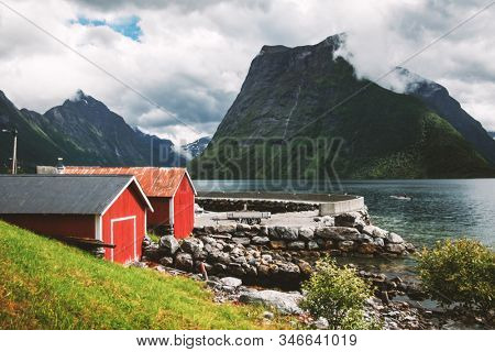 Picturesque scene of Urke village and Hjorundfjorden fjord, Norway. Drammatic sky and gloomy mountains. Landscape photography