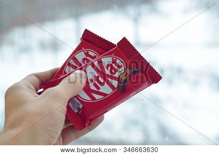 Kit Kat Chocolate Bar In Male Hand On Snowy Background. Kit Kat Created By Rowntrees Of York In Unit