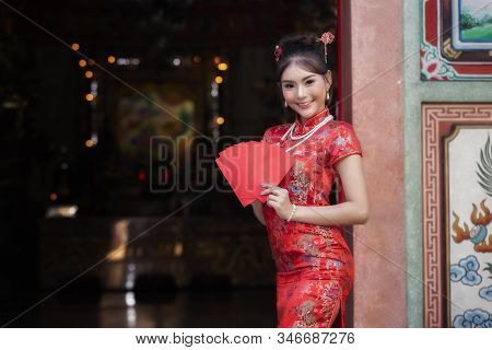 Concept To Celebrate Chinese New Year : Chinese Woman In A Red Cheongsam (qipao) Dress Holding Red E