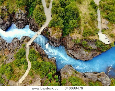 The Aerial View Of The Milky Blue River And A Bridge Near Barnafoss Falls, Iceland.