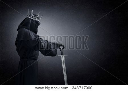 Ghost of a queen or king with medieval sword in the dark