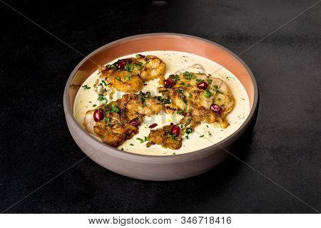 Serving Chkmeruli In A Light Plate On A Black Background