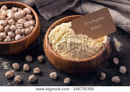 Chickpea flour in a wooden bowl  isolated on a white background