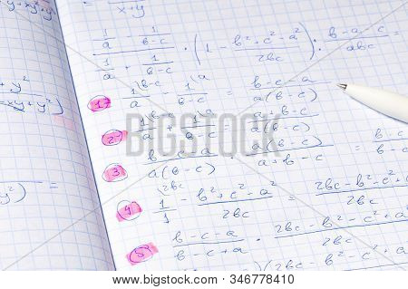 Algebraic Calculations In Open Graph Notebook With Black Pen. White Paper With Math Fractions. Noteb