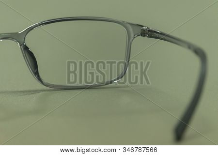 Clear Plastic Glasses, Eyes Closed, Shot Close-up, On A Blurred Green Background. Concept: Beautiful