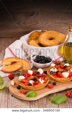 Friselle With Tomatoes And Mozzarella Cheese On Cutting Board.