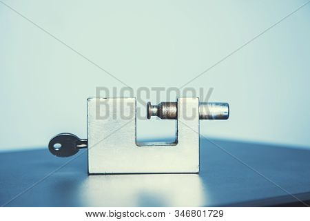 Lock With Key On Tje Wooden Desk Background