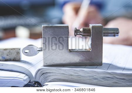 Lock With Key On The Wooden Desk Background