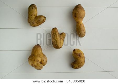 Ugly Vegetables. Potatoes On A White Wooden Background. Top Viev. The Form Does Not Affect The Taste