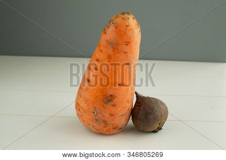 Ugly Vegetables. Carrots And Beets On A White Wooden Background. The Form Does Not Affect The Taste,