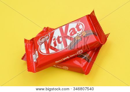 Kit Kat Chocolate Bar In Red Wrapping Lies On Yellow Background. Kit Kat Created By Rowntrees Of Yor