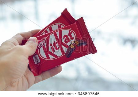 Kit Kat Chocolate Bar In Male Hand On Snowy Background. Kit Kat Created By Rowntrees Of York In Unit