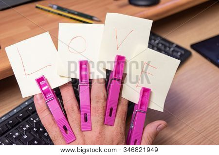 Love Letters With Clothespins In Hand On Top Of Keyboard