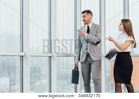 Young Businessman In Hurry, His Secretry Walking On His Side, Reminding Him About All The Meeetings 