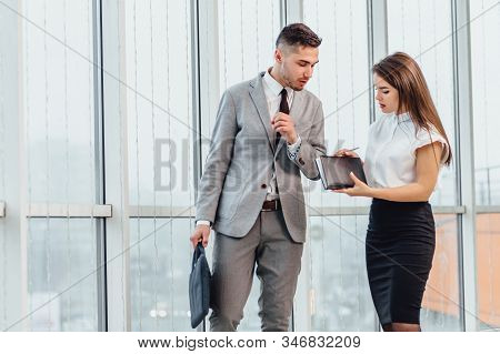 Young Businessman In Hurry, His Secretry Walking On His Side, Reminding Him About All The Meeetings 