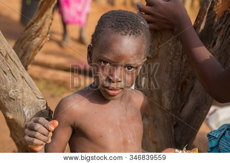 Bissau, Guinea-Bissau - January 5, 2020: portrait on an African Kid looking at the camera in rural Guinea-Bissau