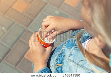 Close-up Little Caucasian Blond Kid Girl Girl In Jeans Jacket Eating White Sweet Mini Marshmallows F