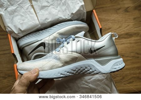 Paris, France - Sep 23, 2019: Pov Man Hand Unboxing Unpacking On Wooden Table Pair Of New Nike Femal