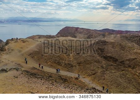 Eilat, Israel - January 18, 2020: View Of Mount Tzfahot And The Gulf Of Aqaba, With Hikers. Eilat Mo