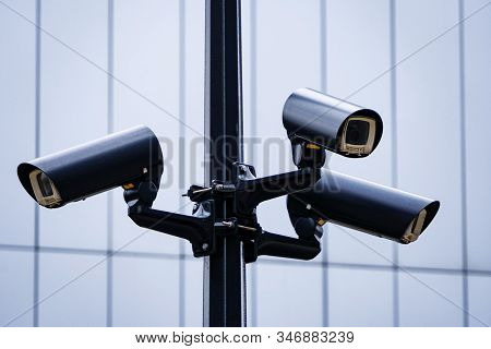 Video Surveillance System On A Pole, Three Cameras Are Turned In Different Directions To Cover The V