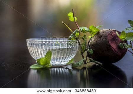 Home Remedy For Dandruff On Wooden Surface I.e., Beetroot Stock Well Mixed With Water In A Glass Bow