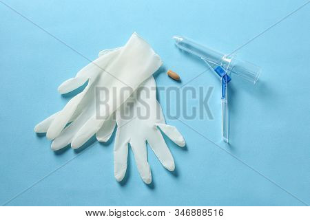 Anoscope, Suppository And Rubber Gloves On Light Blue Background, Flat Lay. Hemorrhoid Treatment