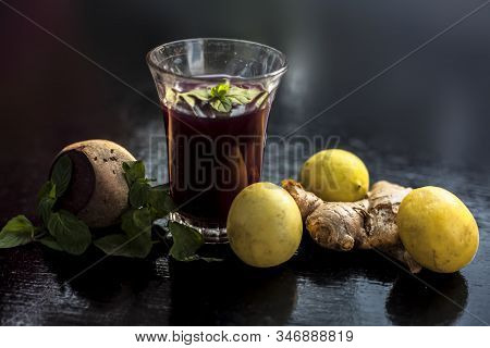 Beetroot Juice With Some Mint Leaves Lemon Juice And Ginger In It On Black Glossy Surface In A Glass