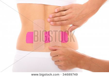 รูปภาพของเทป physio พิเศษถูกวางบนกล้ามเนื้อหลังมากกว่าพื้นหลังสีขาว