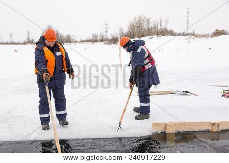 Workers Rafting Ice Blocks Along A Channel Cut Out By A Frozen Lake