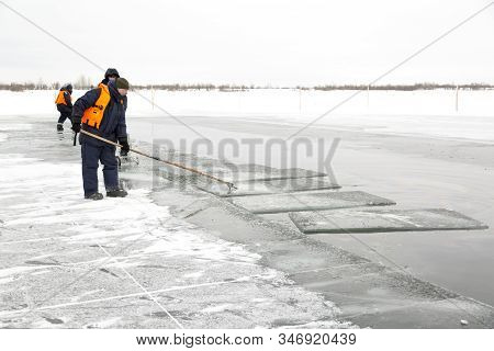 A Working Installer In A Life Jacket Rafts Ice Panels To A Lane With A Hook
