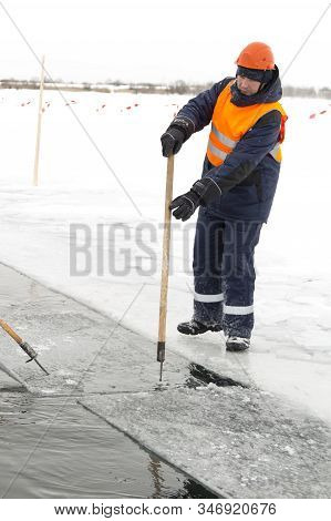 A Working Installer In A Life Jacket Rafts Ice Panels To A Lane With A Hook