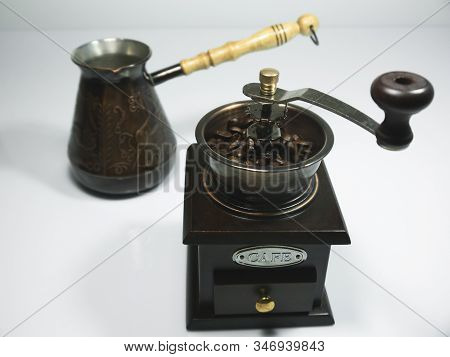 The Wooden Coffee Grinder With Coffee Beans And Cezva On White Background