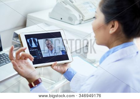 Unrecognizable Female Doctor Taking Part In Online Conference With Her Colleagues Using Her Pad