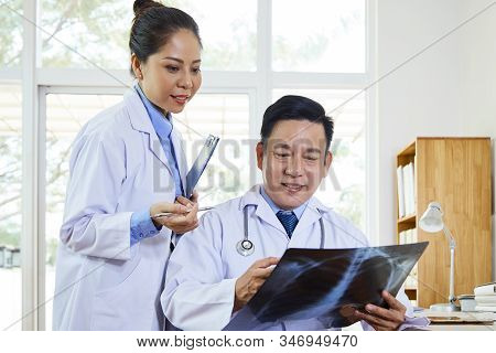 Cheerful Pulmonologist Showing Lungs X-ray Image To His Colleague, Horizontal Shot