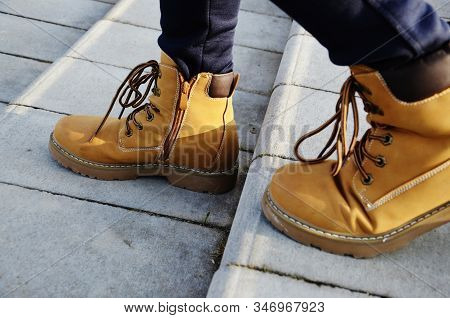 A Girl In Boots Steps Down The Stairs. A Man In Boots Is Walking Down The Stairs. Concept: Deteriora
