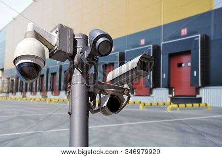 Closed Circuit Camera Multi-angle Cctv System Against The Background Of A Modern Warehouse Complex.