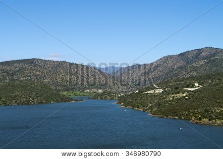 Germasogeia Water Reservoir, Cyprus In Winter With Green Hills Around And The Blue Sky Above