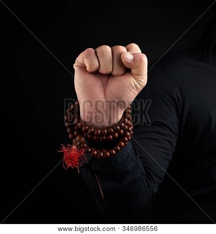 Hand Of An Adult Male Shows Mushti Mudra On A Dark Background, Clenched Fist