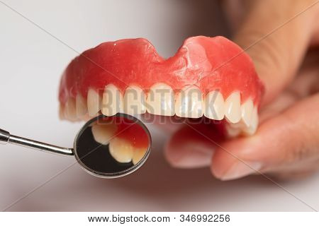 Denture Prosthesis In Doctor Dentist Hands, Checking With Mirror