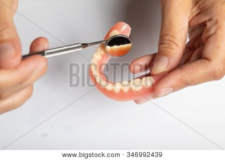 Denture Prosthesis In Doctor Dentist Hands, Checking With Mirror