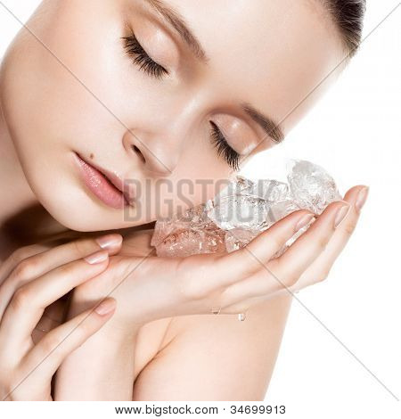 Hermosa mujer con maquillaje aspecto natural con cubitos de hielo cerca de la cara