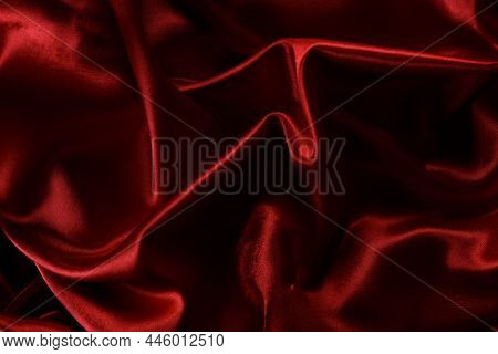 Red Smooth Silk Background. Elegant Bright Satin With Waves. Fabric Backdrop, View From Above. Luxur