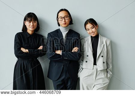 Waist Up Portrait Of Asian Business Team Smiling At Camera Against Miniman Background