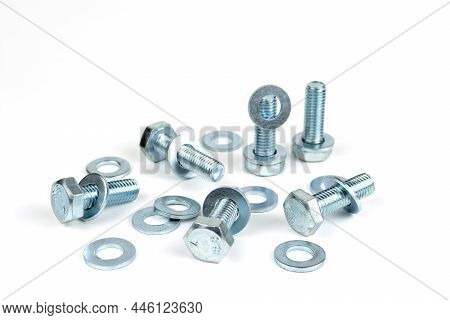 Several Metal Bolts With Washers And Nuts On A White Background. Close-up