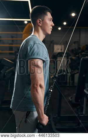 Concentrated Athlete Performing Strength Exercise On Cable Machine