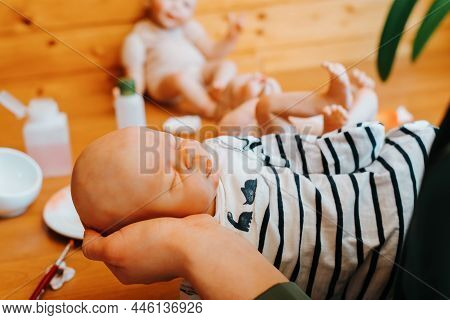 Realistic Reborn Baby Doll, Close-up. Woman Craftsman Holding Handmade Newborn Toy While Sitting At 