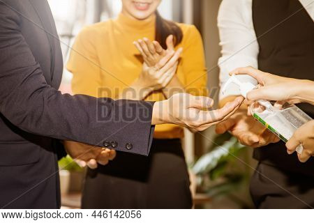 Group Of Business People In The Office Are Cooperating With Alcohol-based Hand Sanitizer Mixed With 
